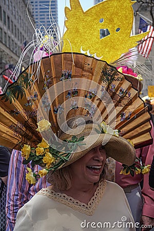 New York, New York: A smiling woman wears an elaborate Easter bonnet with a large fan Editorial Stock Photo