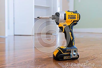 Modern cordless screwdriver, DeWalt drill with drill a wooden floor of new house for the construction Editorial Stock Photo