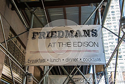 Sign on scaffolding at construction site at front entrance of Friedman`s Restaurant at the Edison Hotel on 47th Street in Editorial Stock Photo