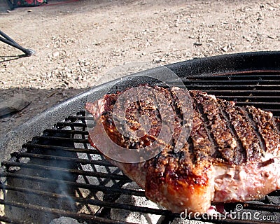 New York Steak Cooking Outdoors on Charcoal Grill Stock Photo