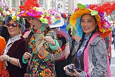 Three Asian women wearing colorful costumes at the Fifth Avenue Easter Parade. Editorial Stock Photo