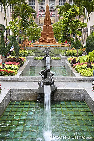 New York, USA â€“ August 23, 2018: Rockefeller Plaza, Beautiful blooming flower, fountain and sculpture in the Channel Gardens at Editorial Stock Photo