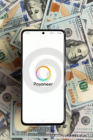 smartphone screen with digital payment service Payoneer mobile application on US dollar banknotes background Editorial Stock Photo