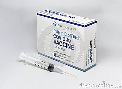 A syringe next to the Pfizer BioNTech Covid-19 vaccine box Editorial Stock Photo