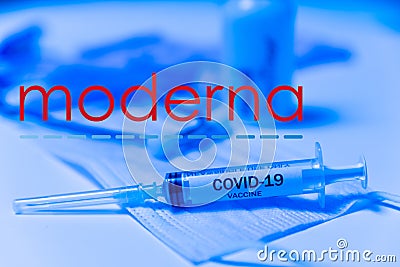 New york, USA - 5 january 2021: moderna covid vaccine closeup of syringe on blue background with face mask. concept of science and Editorial Stock Photo