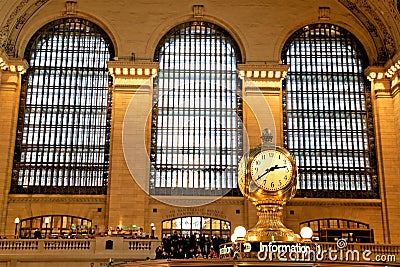 Interior of Main Concourse of Grand Central Terminal with Clock and people walking around. Beautiful windows behind. Closeup Editorial Stock Photo