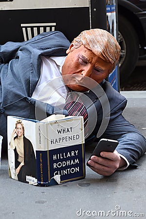 New York, USA - May 30, 2018: Street beggar wears a Trump mask a Editorial Stock Photo