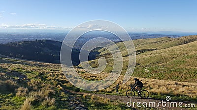 NEW ZEALAND, CHRISTCHURCH - OCTOBER 2016: A pair of unidentified couple mountain biking across Victoria hills of Christchurch New Editorial Stock Photo