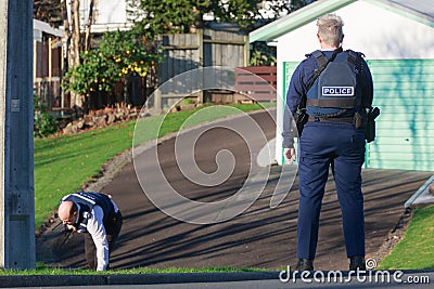 New Zealand police. A policewoman watches while a colleague searches Editorial Stock Photo
