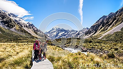 NEW ZEALAND, SOUTH ISLAND, MOUNT COOK - FEBRUARY 2016: A group of young traveler explores Valley track. Working holiday Editorial Stock Photo