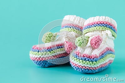 Newborn announcement. knitted baby booties on plain blue backgro Stock Photo