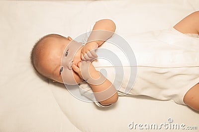 Newborn Asian baby girl lying on a bed. Stock Photo