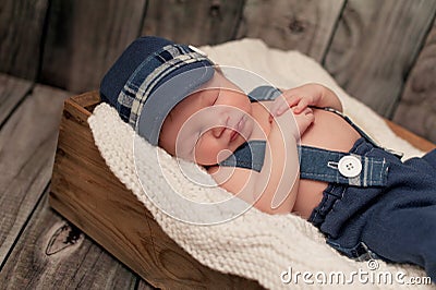Newborn Baby Boy Wearing a Newsboy Cap and Suspenders Stock Photo