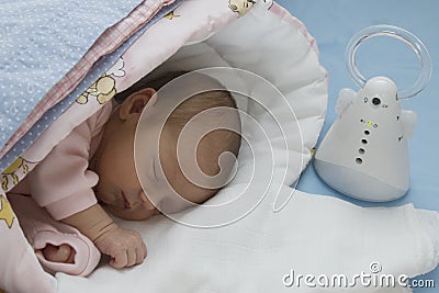 Newborn baby and electronic nanny Stock Photo