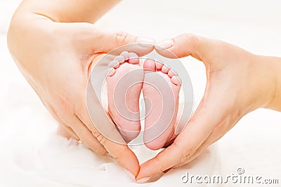 Newborn Baby Feet in Mother Hands Heart, Mom and New Born Kid Foot Stock Photo