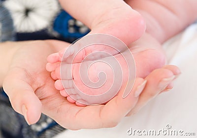 Newborn baby foots in mothers hands Stock Photo