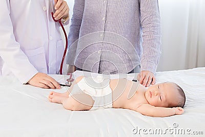 Newborn baby get sick sleeping on hospital bed while pediatrician doctor talking with mother about baby sickness in clinic, Stock Photo