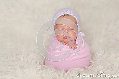 Newborn Baby Girl with Pink Bonnet and Swaddle Stock Photo