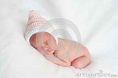 Newborn Baby Girl Wearing Pink and White Pixie Hat Stock Photo