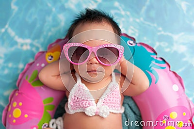 Newborn Baby Girl Wearing Sunglasses and a Bikini Top Stock Photo