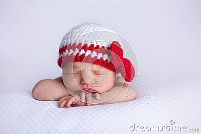 Newborn Baby Girl Wearing a White and Red Crocheted Cap Stock Photo