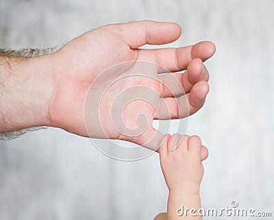 Newborn baby grabbed the little finger of his father Stock Photo