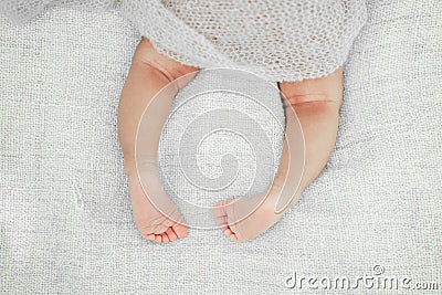 Newborn Baby legs on the bed. Cute little baby lying on bed. Stock Photo