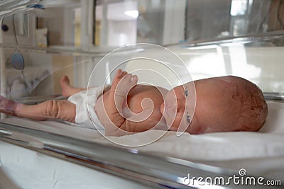 Newborn baby lies on a drip in a hospital Stock Photo