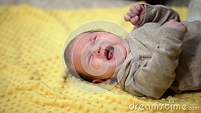 Newborn baby lying and crying suffering abdominal colic, emergence of tooth Stock Photo