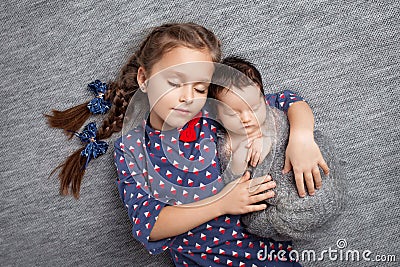 Newborn baby with sister. Cute girl lying with her little brother. Happy sister embracing her newborn baby brother Stock Photo