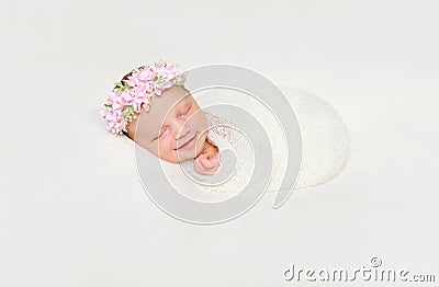 Newborn baby swaddled in white diaper smiling asleep Stock Photo