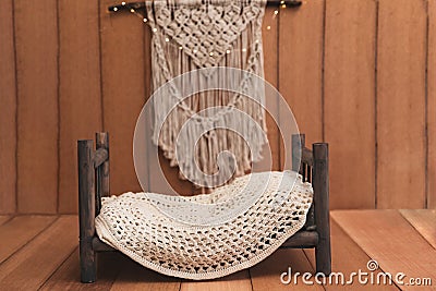 Newborn background - wooden bed with rustic throw and macrame Stock Photo