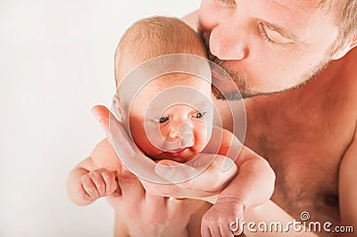 Newborn on the bed with his father close-up. The concept of the relationship of children and parents from birth. Stock Photo