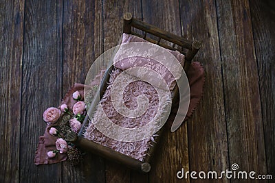 Newborn digital background - dark wooden bed with pink faux fur and lace pillow on dark wooden floor mat with jute and pink layer Stock Photo