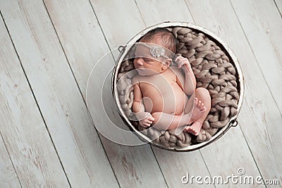 Newborn Girl Sleeping in Wooden Bowl Stock Photo
