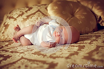 Newborn healthy baby 2 weeks old is lying in a posh bedroom on t Stock Photo