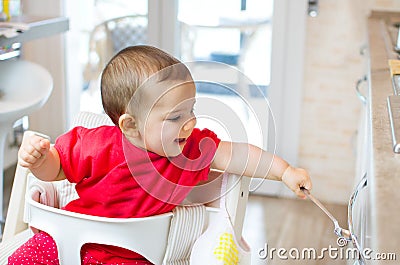 Newborn high chair play beating kitchen drawer spoon - heuristic Stock Photo