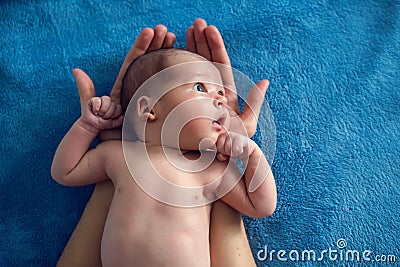 Newborn lies on two arms of his father Stock Photo