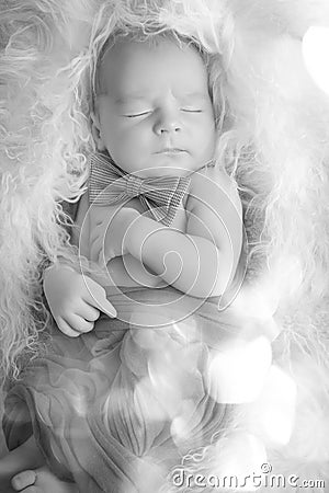 A newborn sleeping in a smart bow tie, tiny baby. A black and white portrait. Mom and her baby. The concept of a happy family. Stock Photo