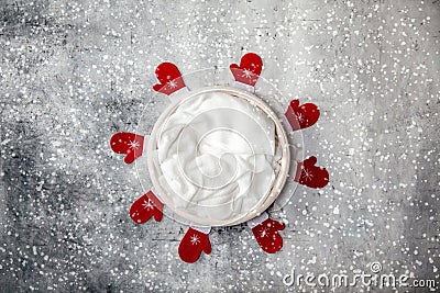 Newborn winter background - round cream bowl with CHristmas red garland on snowy backdrop Stock Photo