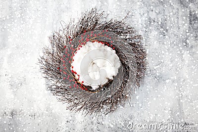 Newborn winter background - rustic natural wreath with white fluffy layer on snow covered backdrop Stock Photo