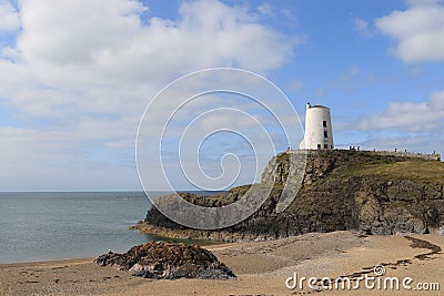 TÅµr Mawr lighthouse, on Ynys Llanddwyn on Anglesey, Wales, marks the western entrance to the Menai Strait. Stock Photo