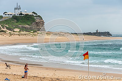 Sandy beach and Nobbys lighthouse at ocean in Newcastle, Australia Editorial Stock Photo