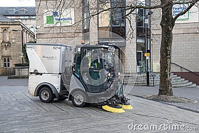 Road street sweeping vehicle with brushes on the road being driven to clean urban environment Editorial Stock Photo