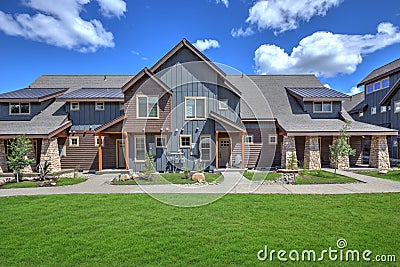 Newly build modern and rustic home from exterior in natural brown and grey colors with walkways, green grass and natural stone Stock Photo