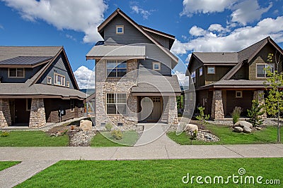 Newly build modern and rustic home from exterior in natural brown and grey colors with walkways, green grass and natural stone Stock Photo