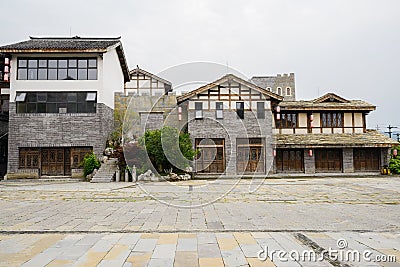 Newly built tile-roofed buildings by flagstone street in cloudy Editorial Stock Photo