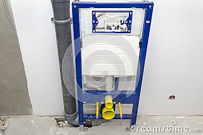 Newly installed WC concealed frame for wall-mounted toilet connected to the aeration pipe and sewage system in the bathroom. Stock Photo