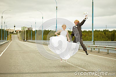 Newly married pair jumps on highway Stock Photo