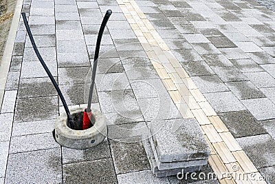 Newly paved sidewalk with guidelines for the visually impaired and a concrete base for a light pole Stock Photo